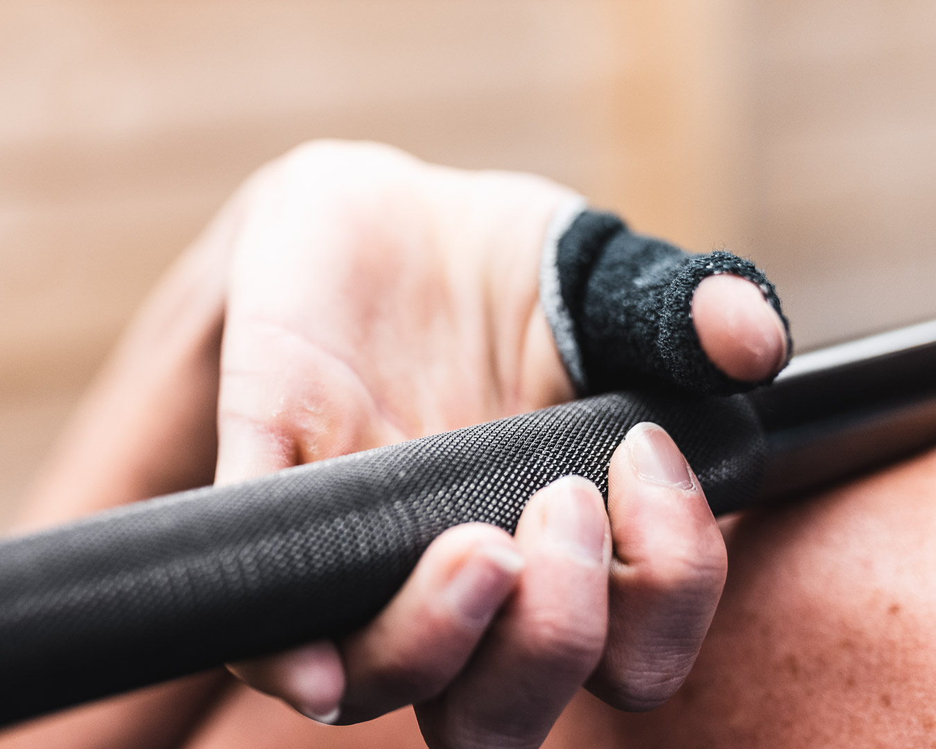 Thumb tape around hands while lifting a barbell in CrossFit