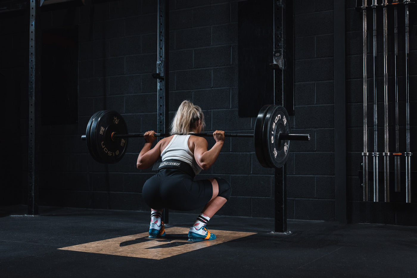 A detailed, step-by-step guide on mastering the perfect squat. The first image depicts a Middle-Eastern man demonstrating the starting position, standing straight. The second shows a Hispanic woman ha